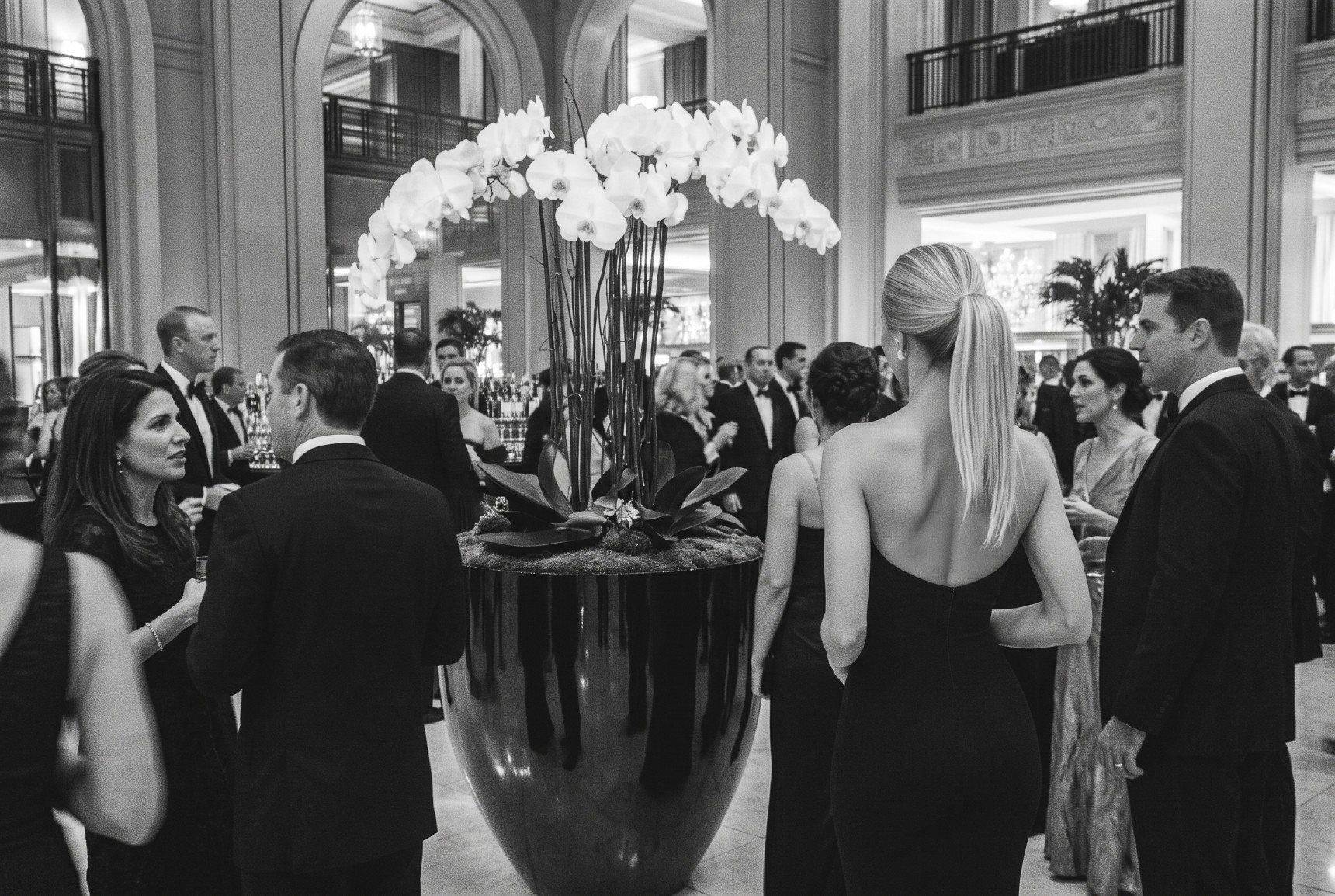 Sala allestita per una cena di gala aziendale, con tavoli rotondi apparecchiati e schermo per le proiezioni